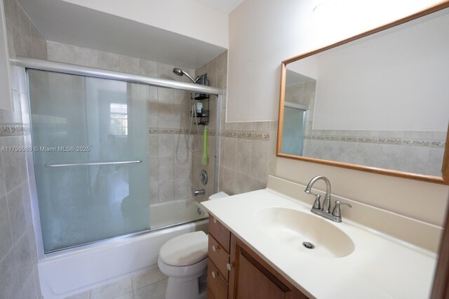 12840 SW 146th Ln, Miami, FL 33186 - bathroom featuring vanity, shower / bath combination with glass door, toilet, tile walls, and tile patterned floors