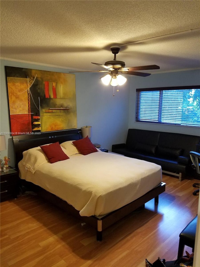 bedroom featuring wood finished floors, a textured ceiling, and ceiling fan