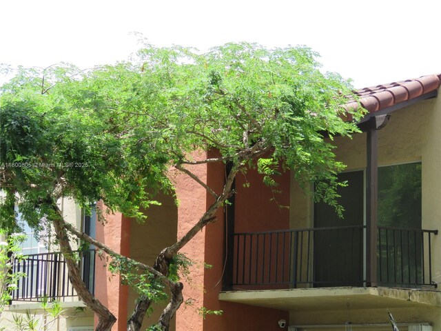 view of property exterior with stucco siding and a balcony