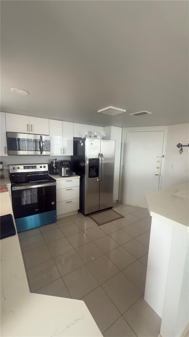 1351 NE Miami Gardens Dr Unit 1225E, Miami, FL 33179 - kitchen featuring appliances with stainless steel finishes, white cabinets, and light tile patterned floors