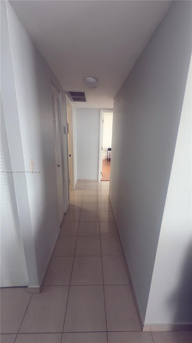 1351 NE Miami Gardens Dr Unit 1225E, Miami, FL 33179 - corridor featuring light tile patterned flooring and baseboards