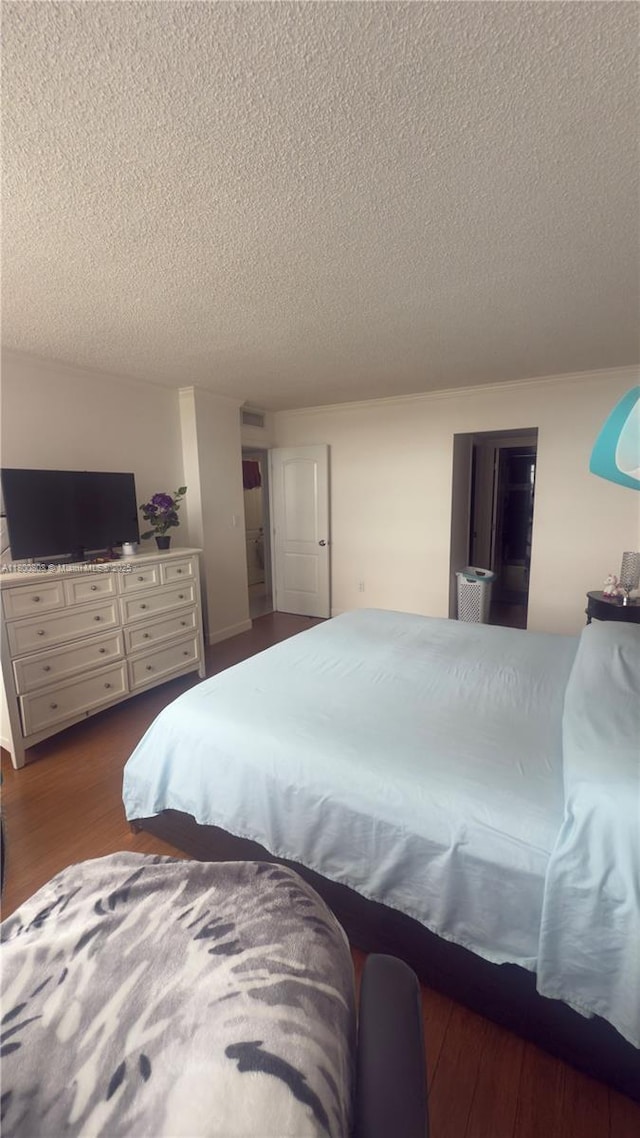 1351 NE Miami Gardens Dr Unit 1225E, Miami, FL 33179 - bedroom with a textured ceiling and dark wood finished floors