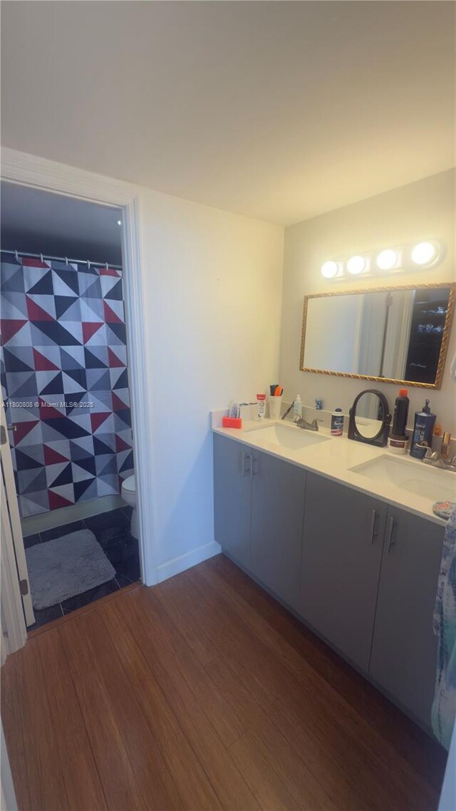 1351 NE Miami Gardens Dr Unit 1225E, Miami, FL 33179 - bathroom with wood finished floors, double vanity, toilet, and a shower with shower curtain