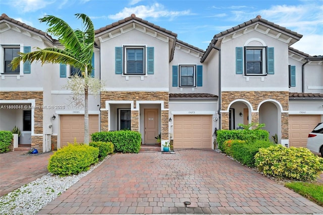 15073 SW 119th Ln, Miami, FL 33196 - townhome / multi-family property featuring stone siding, stucco siding, decorative driveway, and a tile roof