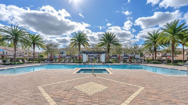 15073 SW 119th Ln, Miami, FL 33196 - community pool featuring a hot tub, a patio area, and a residential view