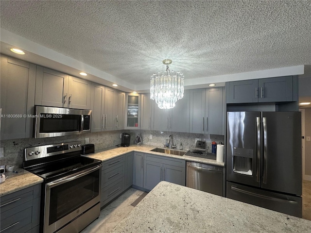 1865 S Ocean Dr Unit 17C, Hallandale Beach, FL 33009 - kitchen with appliances with stainless steel finishes, a sink, a chandelier, gray cabinetry, and a textured ceiling