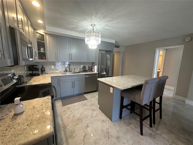 1865 S Ocean Dr Unit 17C, Hallandale Beach, FL 33009 - kitchen with stainless steel appliances, a chandelier, decorative backsplash, a breakfast bar area, and a sink