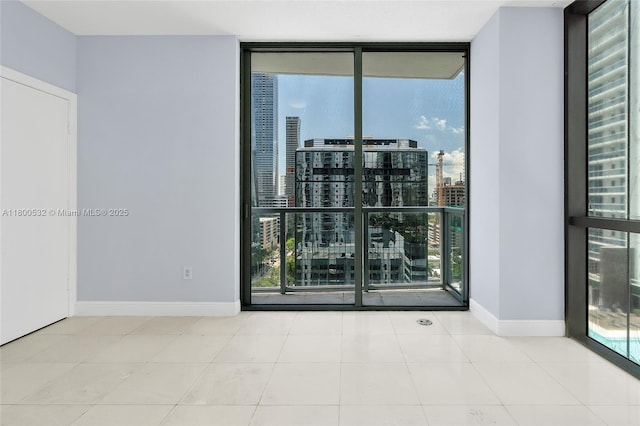 1060 Brickell Ave Unit 1811, Miami, FL 33131 - tiled spare room featuring a wall of windows, baseboards, and a city view