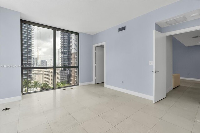 1060 Brickell Ave Unit 1811, Miami, FL 33131 - tiled empty room with floor to ceiling windows, baseboards, and a city view