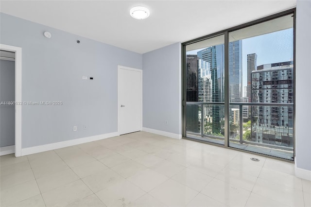 1060 Brickell Ave Unit 1811, Miami, FL 33131 - unfurnished room featuring floor to ceiling windows, baseboards, a view of city, and a smoke detector