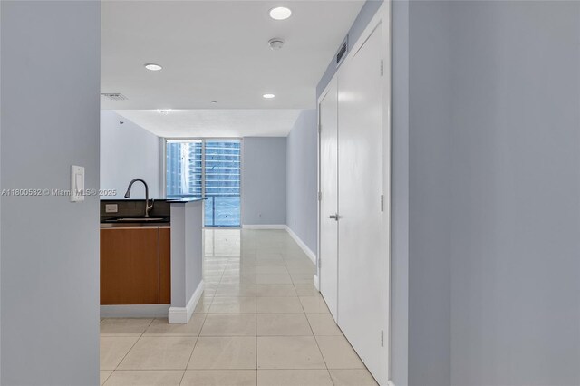 1060 Brickell Ave Unit 1811, Miami, FL 33131 - corridor with a sink, light tile patterned flooring, floor to ceiling windows, baseboards, and recessed lighting
