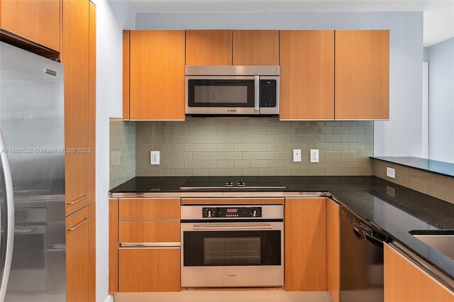 1060 Brickell Ave Unit 1811, Miami, FL 33131 - kitchen with black appliances, backsplash, and dark stone countertops