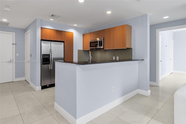 1060 Brickell Ave Unit 1811, Miami, FL 33131 - kitchen with stainless steel appliances, dark countertops, a peninsula, decorative backsplash, and recessed lighting