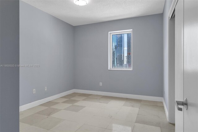 1060 Brickell Ave Unit 1811, Miami, FL 33131 - spare room featuring baseboards and a textured ceiling