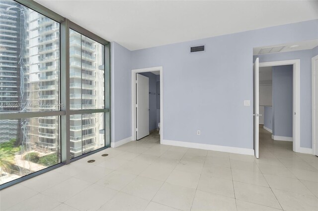 1060 Brickell Ave Unit 1811, Miami, FL 33131 - empty room with healthy amount of natural light, a wall of windows, and baseboards