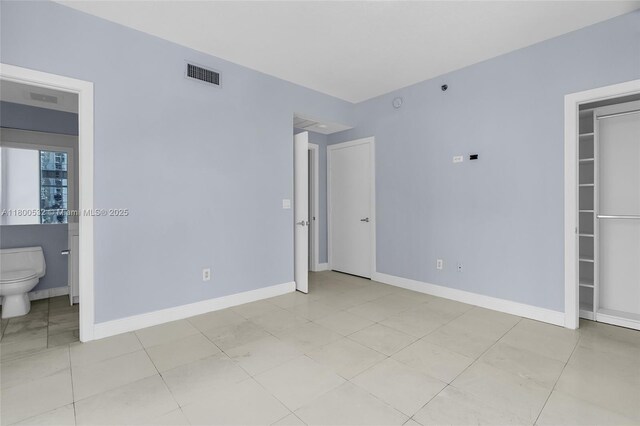 1060 Brickell Ave Unit 1811, Miami, FL 33131 - unfurnished bedroom featuring baseboards and connected bathroom