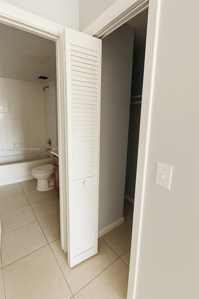 full bathroom with tile patterned floors, toilet, washtub / shower combination, and vanity