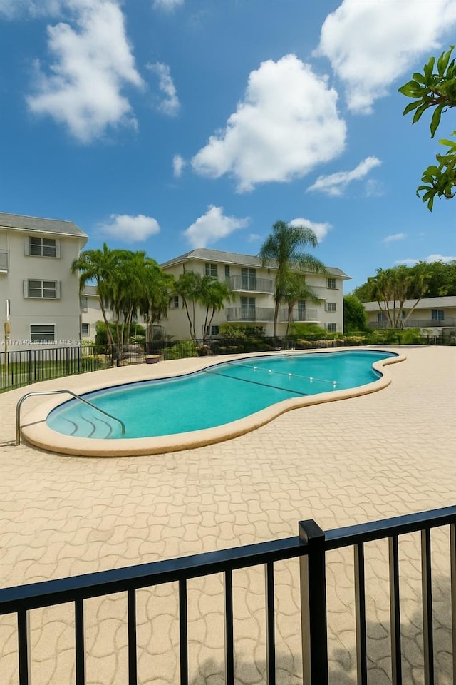 community pool featuring a patio and fence