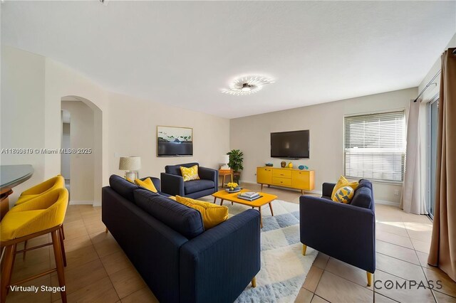 13781 NW 16th St, Pembroke Pines, FL 33028 - living room with arched walkways, light tile patterned flooring, and baseboards