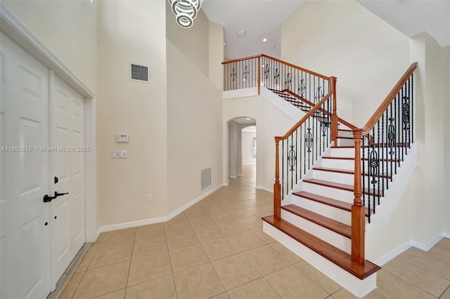 13781 NW 16th St, Pembroke Pines, FL 33028 - stairway with arched walkways, a towering ceiling, tile patterned floors, and baseboards