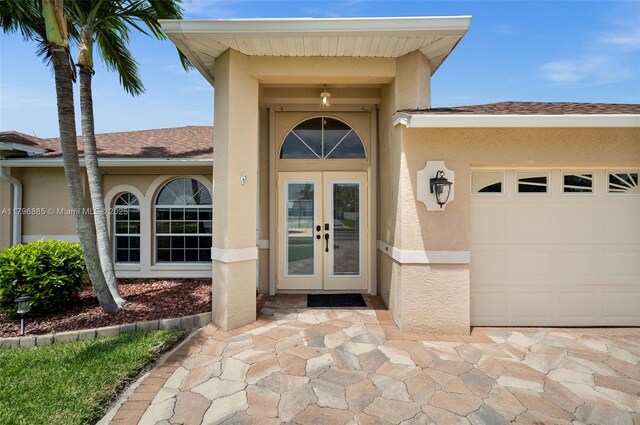 4344 Agualinda Blvd, Cape Coral, FL 33914 - view of exterior entry with french doors, stucco siding, and an attached garage