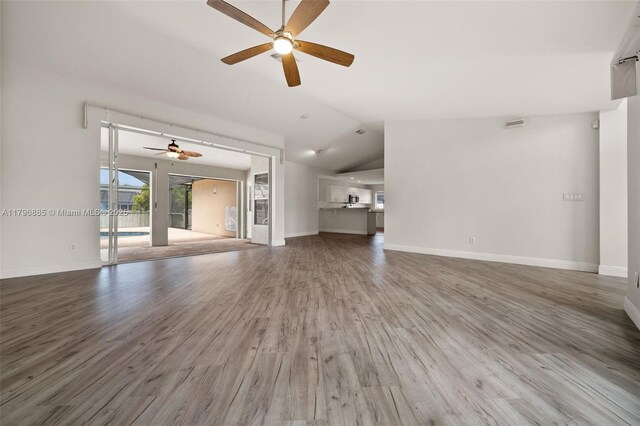 4344 Agualinda Blvd, Cape Coral, FL 33914 - unfurnished living room featuring ceiling fan, wood finished floors, vaulted ceiling, and baseboards
