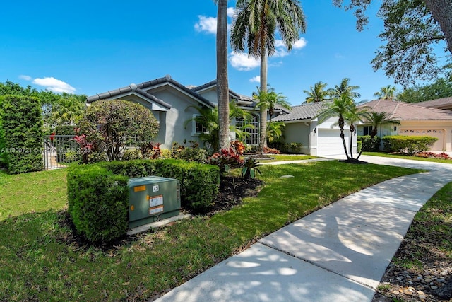 218 Egret Ct, Weston, FL 33327 - view of front of home with a tiled roof, concrete driveway, a front yard, and a garage
