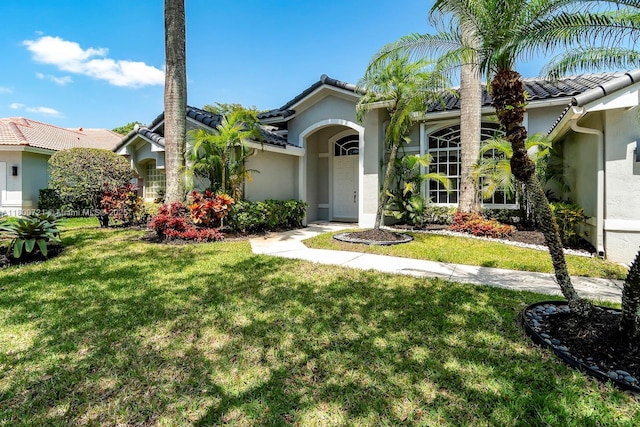 218 Egret Ct, Weston, FL 33327 - mediterranean / spanish house with stucco siding, a tile roof, and a front yard