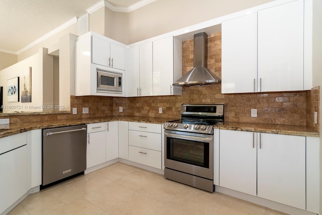 218 Egret Ct, Weston, FL 33327 - kitchen featuring stainless steel appliances, wall chimney exhaust hood, crown molding, white cabinets, and dark stone counters
