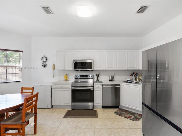 17616 SW 135th Ave, Miami, FL 33177 - kitchen featuring stainless steel appliances, light countertops, white cabinetry, and light tile patterned floors
