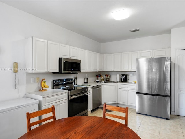 17616 SW 135th Ave, Miami, FL 33177 - kitchen with stainless steel appliances, light countertops, white cabinets, and light tile patterned floors