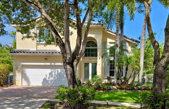 1811 SW 162nd Ave, Miramar, FL 33027 - mediterranean / spanish home with french doors, an attached garage, stucco siding, driveway, and a tile roof