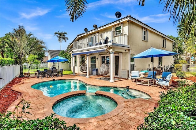 1811 SW 162nd Ave, Miramar, FL 33027 - rear view of house with a balcony, a fenced backyard, a patio, outdoor dining space, and a pool with connected hot tub