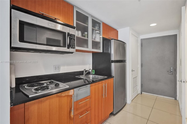 1750 N Bayshore Dr Unit 4007, Miami, FL 33132 - kitchen featuring appliances with stainless steel finishes, a sink, dark countertops, glass insert cabinets, and light tile patterned floors