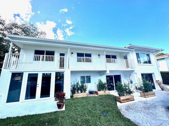 10361 NE 4th Ave, Miami Shores, FL 33138 - back of property featuring stucco siding, french doors, a lawn, and a balcony