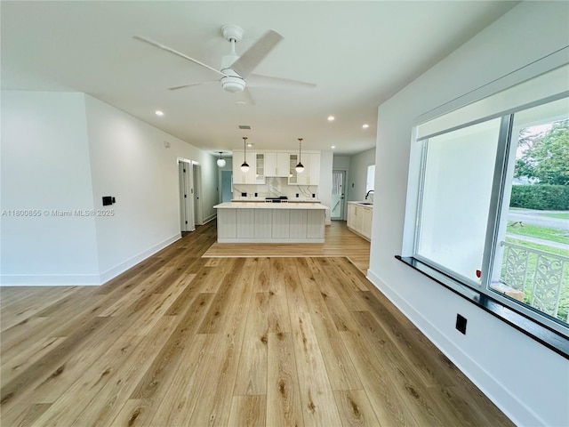 10361 NE 4th Ave, Miami Shores, FL 33138 - unfurnished living room with light wood-type flooring, recessed lighting, ceiling fan, a sink, and baseboards