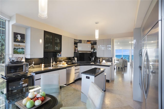 17555 Collins Ave Unit 308, Sunny Isles Beach, FL 33160 - kitchen with stainless steel appliances, a center island, hanging light fixtures, glass insert cabinets, and white cabinetry