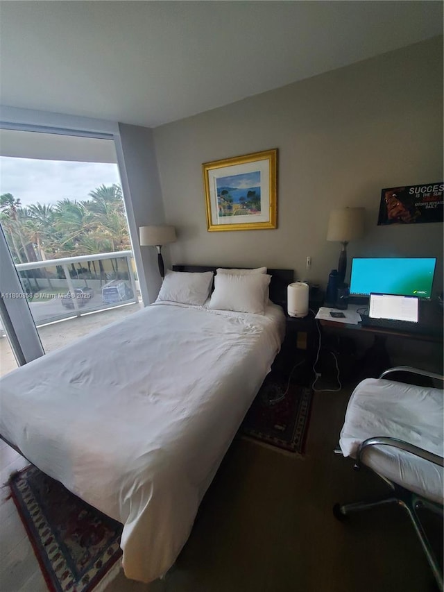 bedroom with access to outside and wood finished floors