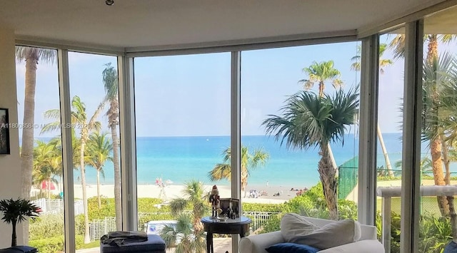 sunroom featuring expansive windows and a water view