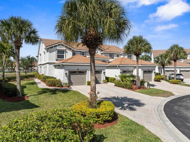 6893 Sterling Grns Unit 201, Naples, FL 34104 - mediterranean / spanish house featuring concrete driveway, stucco siding, a front yard, a garage, and a tile roof