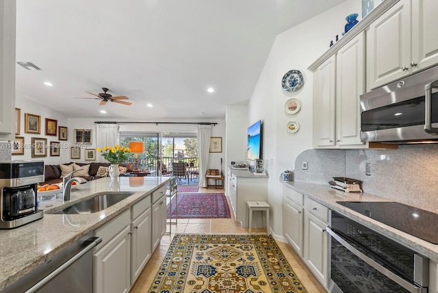 6893 Sterling Grns Unit 201, Naples, FL 34104 - kitchen with appliances with stainless steel finishes, a sink, backsplash, a ceiling fan, and white cabinets