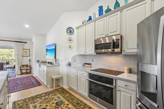 6893 Sterling Grns Unit 201, Naples, FL 34104 - kitchen with stainless steel appliances, backsplash, light tile patterned floors, and white cabinetry