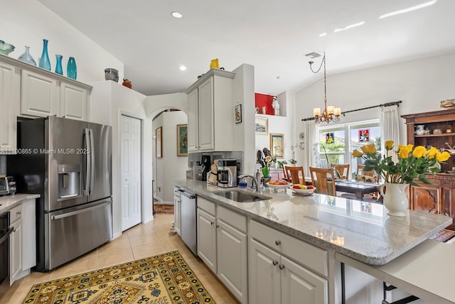 6893 Sterling Grns Unit 201, Naples, FL 34104 - kitchen with stainless steel appliances, a sink, arched walkways, a peninsula, and a chandelier