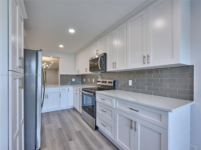 5380 Cedar Lake Dr Unit 204, Boynton Beach, FL 33437 - kitchen featuring appliances with stainless steel finishes, white cabinetry, light countertops, light wood-style floors, and recessed lighting