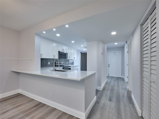 5380 Cedar Lake Dr Unit 204, Boynton Beach, FL 33437 - kitchen featuring appliances with stainless steel finishes, light wood finished floors, baseboards, light countertops, and recessed lighting
