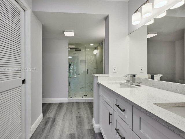 5380 Cedar Lake Dr Unit 204, Boynton Beach, FL 33437 - bathroom featuring a marble finish shower, wood finished floors, double vanity, and baseboards
