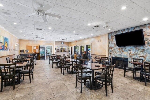 5380 Cedar Lake Dr Unit 204, Boynton Beach, FL 33437 - tiled dining space featuring ceiling fan, a paneled ceiling, and a fireplace