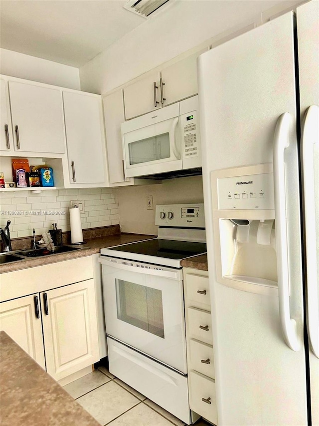 3000 NE 16th Ave Unit 209, Oakland Park, FL 33334 - kitchen with white appliances, a sink, backsplash, light tile patterned flooring, and dark countertops