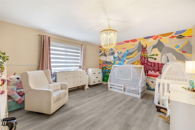 bedroom with wood finished floors and a chandelier