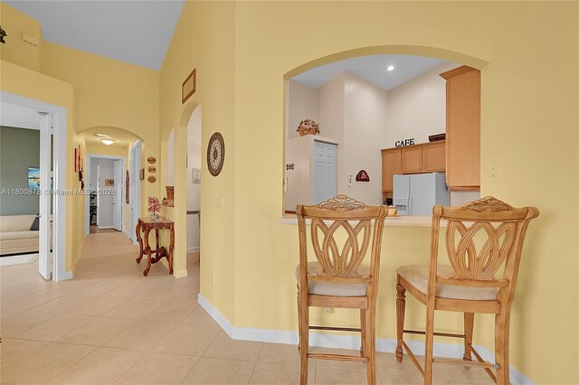 23157 Addison Lakes Cir, Boca Raton, FL 33433 - hall with a high ceiling, arched walkways, light tile patterned floors, and baseboards